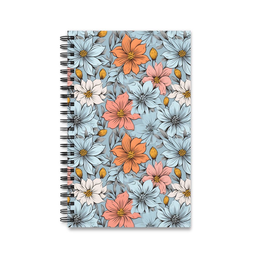 Mit floralem Aquarellmuster zeigt das Notizbuch gro&szlig;e Bl&uuml;ten in Blau, Orange und Rosa auf hellblauem Grund sowie eine schwarze Spiralbindung.