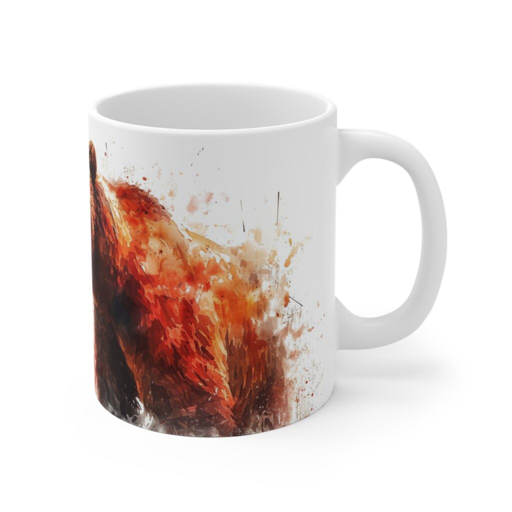 Eine wei&szlig;e Keramiktasse zeigt ein lebendiges Aquarellmotiv mit Grizzlyb&auml;r in Rot-, Braun- und Oranget&ouml;nen.